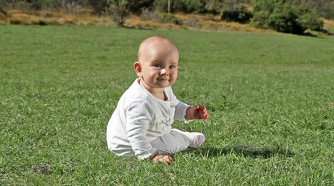 Baby playing on grass, from back Stock Footage 22581884
