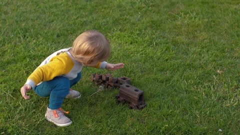 Baby playing with rusty toy train Stock Footage 312529661