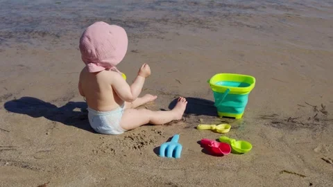 Baby playing on sandy beach with beach toys Video stock 340002399