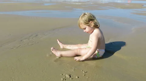 Baby playing in seashore puddle Stock Footage 58250896