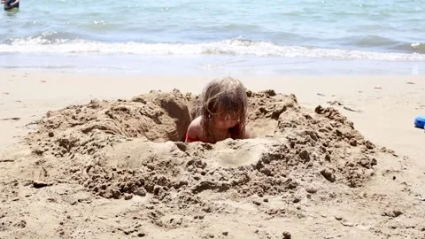 Baby playing with send on beach Stock Footage 163971595
