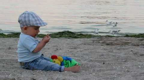 Baby playing with a shell on the seashore Video stock 12274920