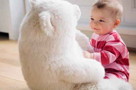 Baby playing with teddy bear Stock Photos