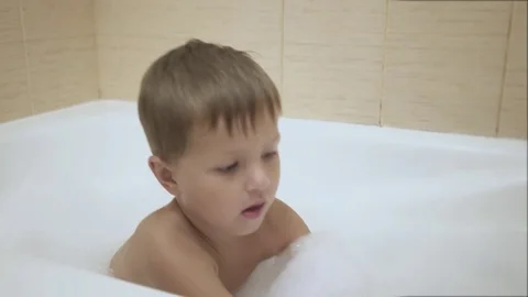 A baby plays with bubbles while taking a bath. Smile Stock Footage 77260083