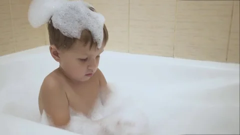 Baby plays with bubbles while taking a bath Stock Footage 77260275