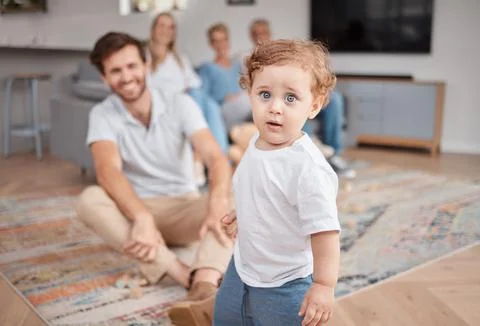 Baby, portrait and play in living room with family, curious and energy, cute and Stock Photos