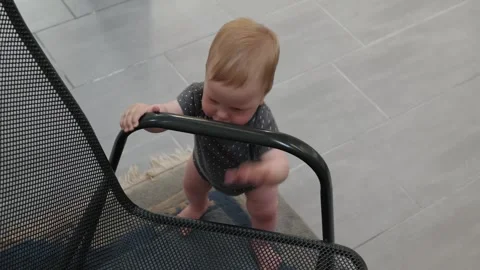 Baby pulling up on mesh chair Stock Footage 339191551