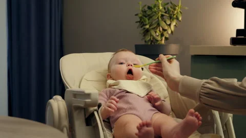 Baby Refuses to Eat Vegetable Puree in High Chair Stock Footage 303368918