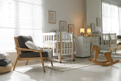 Baby room interior with crib, rocking horse and armchair Stock Photos
