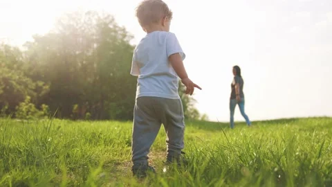 Baby run the first steps. kid running in nature on the grass in park silhouette Stock Footage 169618532
