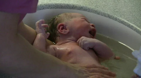 Baby s first bath after birth Stock Footage