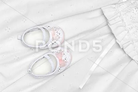 Baby shoes on dress Stock Photos