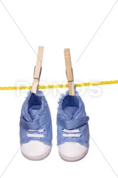 Baby shoes hanging on a clothesline Stock Photos