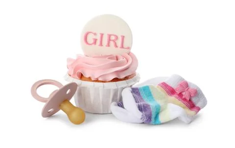 Baby shower cupcake with Girl topper near pacifier and socks on white backgro Stock Photos