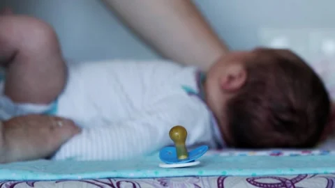A baby silicone pacifier in the foreground against the background of a baby Stock Footage 296578475