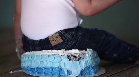 Baby sits on cake Stock Footage 61926499