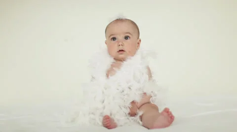 Baby sitting in feathers Stock Footage 23740729