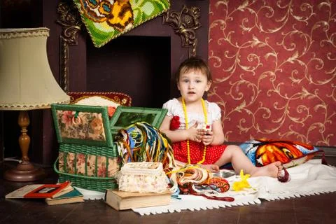 Baby sitting by fireplace with thread Stock Photos