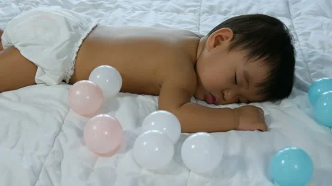 Baby sleeping on a bed Stock Footage 135510433