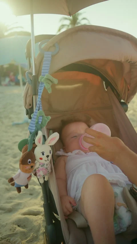 Baby sleeping comfortably in a stroller, drinking from a bottle, with toys Stock Footage 343226449