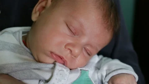 The baby is sleeping hand, it put my head on his shoulder.  Close-up, real time, Stock Footage 86085311
