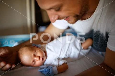 Baby sleeping while father protect him Stock Photos