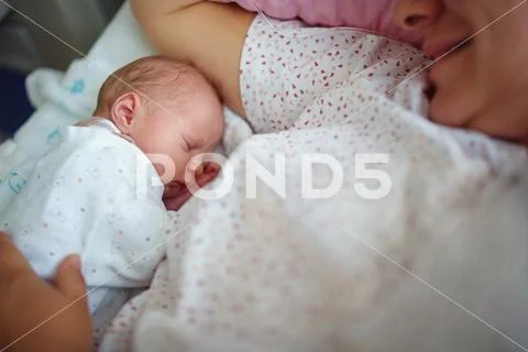 Baby sleeps near mother Stock Photos