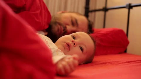 Baby sleeps peacefully beside his father Stock Footage 59776379