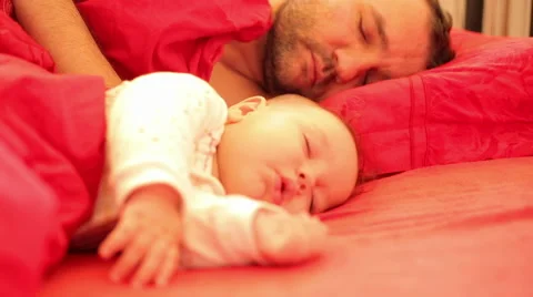 Baby sleeps peacefully beside his father Stock Footage 59776645