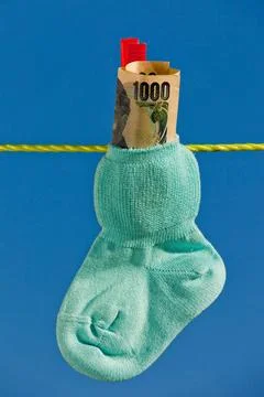 Baby Socken auf Wäscheleine mit Yen Geldscheinen Baby Socken auf Wäschele. Stock Photos