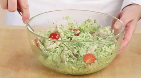 Baby spinach being added to chicken and orzo salad Stock Footage 24656402