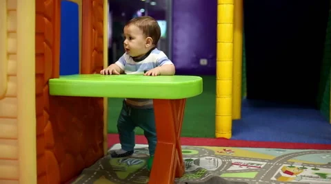 Baby stand at the table in playground Stock Footage 61412685