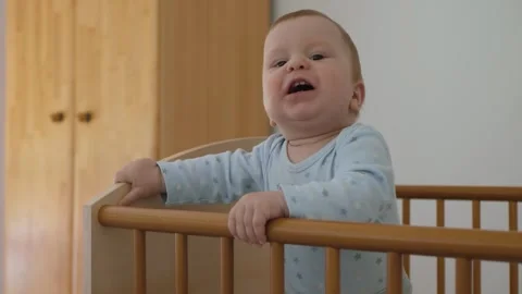 Baby standing in crib Stock Footage 321899830