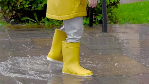 Baby Stomping Through Puddles In Yellow Rubber Boots Slow Motion Stock Footage