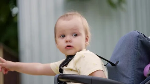 Baby in stroller looking around outdoors Stock Footage 340430983
