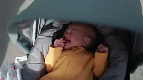 Baby in stroller stops crying after being given a pacifier Stock Footage 189351526