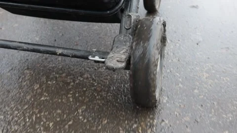 Baby stroller wheel on mud close up, slow motion Stock Footage 220734898