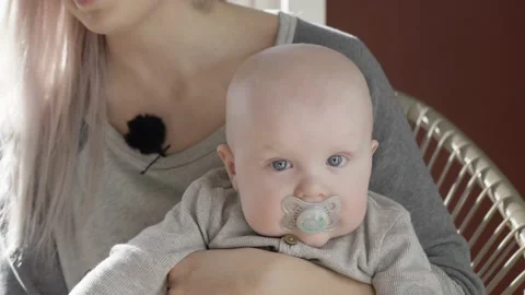 Baby sucking pacifier dummy while mother sitting having relaxing Video stock 130649819