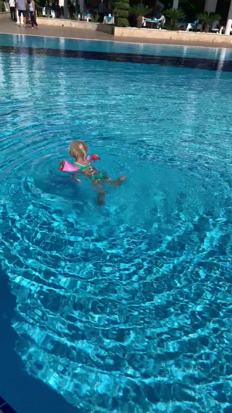 Baby swims in the pool Stock Footage 233965988