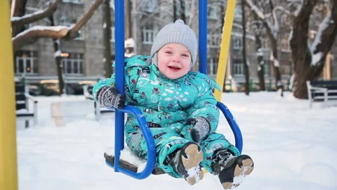 Baby on a swing in winter Video stock 148434484