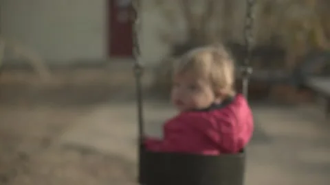 Baby swinging looking back at camera Stock Footage 142655056