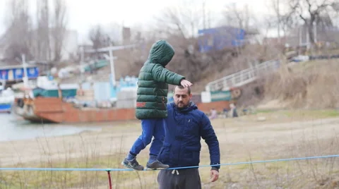 Baby takes its first steps on Slacklining Stock Footage 60445323