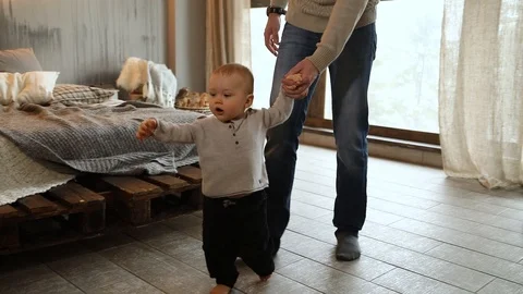 Baby taking first steps, child learning to walk Video stock 102339603