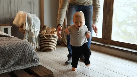 Baby taking first steps, child learning to walk Stock Footage 102339604
