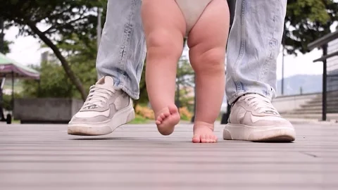 Baby taking their first steps Stock Footage 239120626
