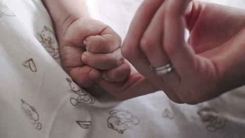Baby tiny brush tightly squeezes the finger of the mother Stock Footage 87917327