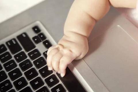Baby touching computer keyboard Stock Photos
