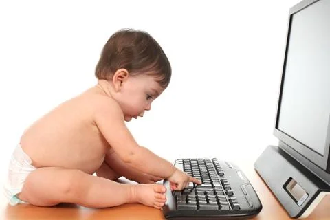 Baby typing enter on a computer keyboard Stock Photos