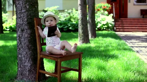 Baby using calculator in the garden Stock Footage 64938469