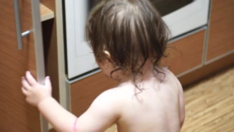 Baby with a wet head opened the kitchen door Stock Footage 138809037